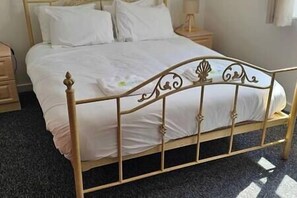 Cozy retreat with a single bed, featuring a metal frame and white linens.