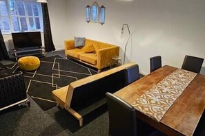 Relax in this stylish living room with a dining table, sofa, and geometric rug.