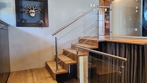 A modern staircase with glass railings and wooden steps.