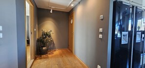 Stylish hallway with a potted plant and two doors leading to separate spaces.