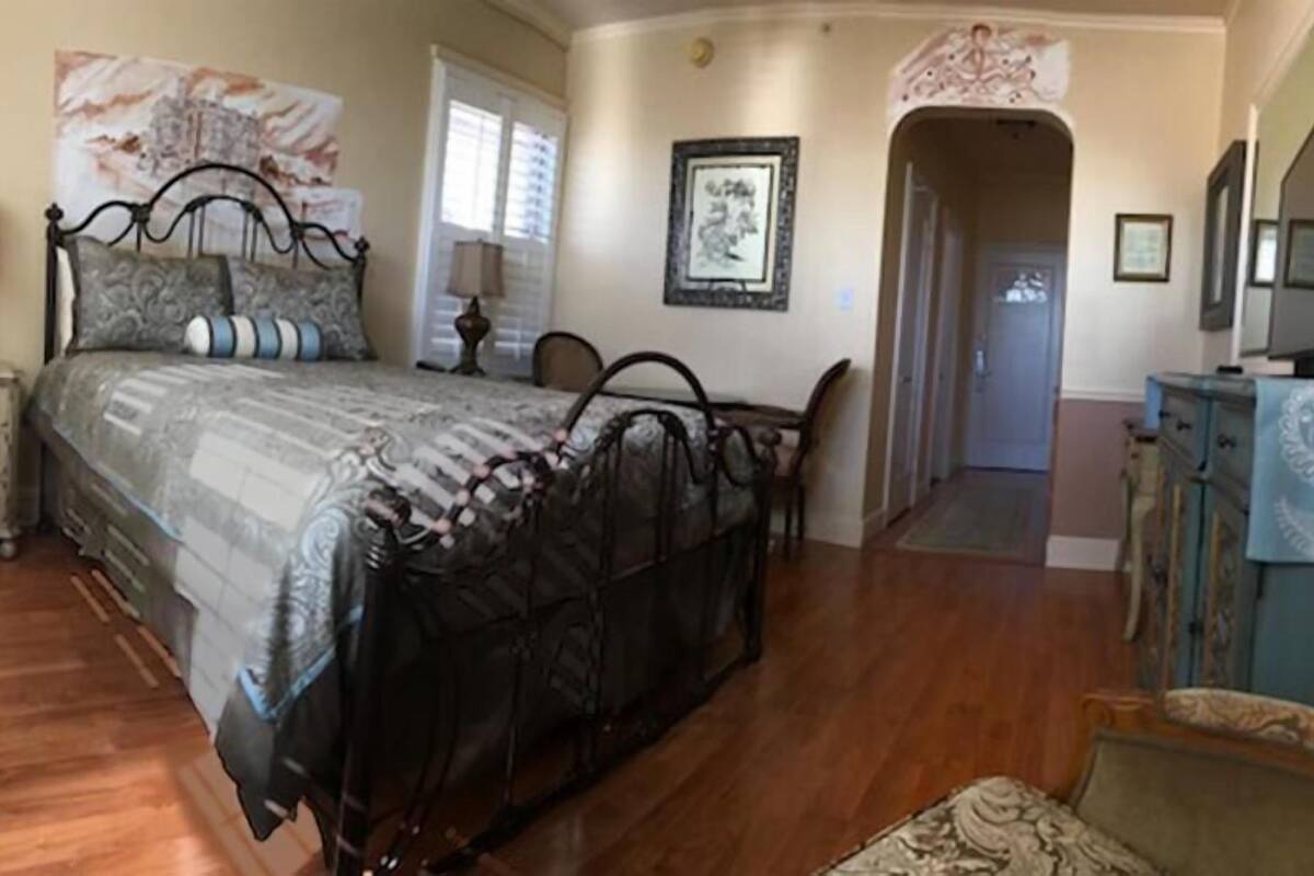 Un dormitorio con cama, mesita de noche, cómoda y espejo.