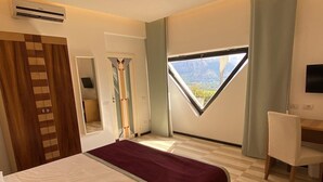 A modern hotel room with a large bed, a desk, and a window with a mountain view. - B&B Villa La Ventana (Sant'Agnello)