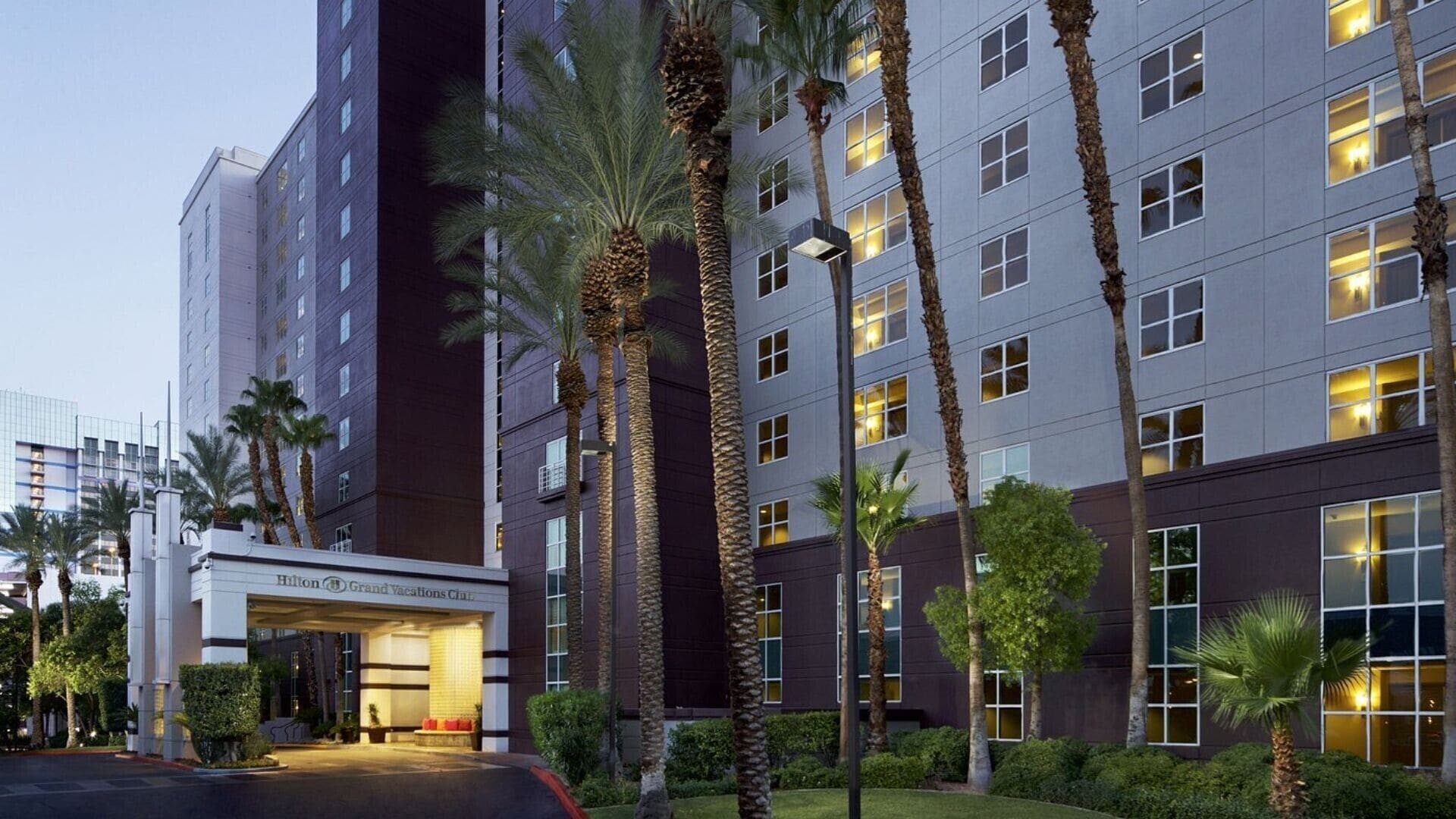 A hotel with a modern facade, multiple floors, and a well-lit entrance.