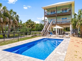 Un bâtiment à deux étages doté d’une piscine, d’un espace extérieur aménagé et d’un patio couvert.