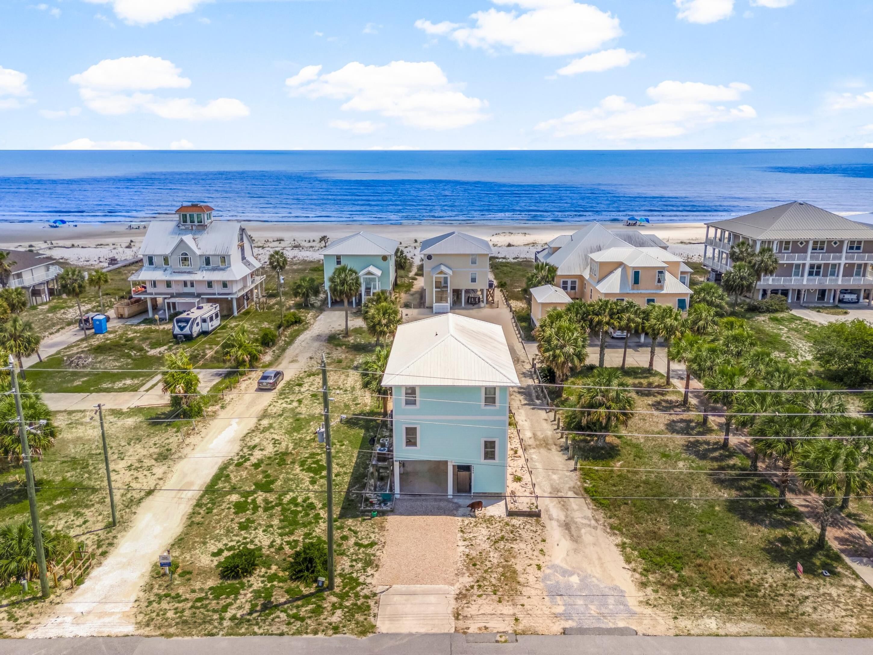 Zona residencial costera con casas, una playa y cielo despejado.