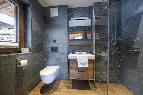A modern bathroom with a toilet, sink, and shower.