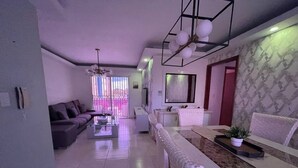 Una sala de estar moderna con sofá, mesa de centro y comedor con banco y mesa.