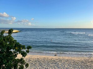 Una playa con cielos despejados y aguas tranquilas.