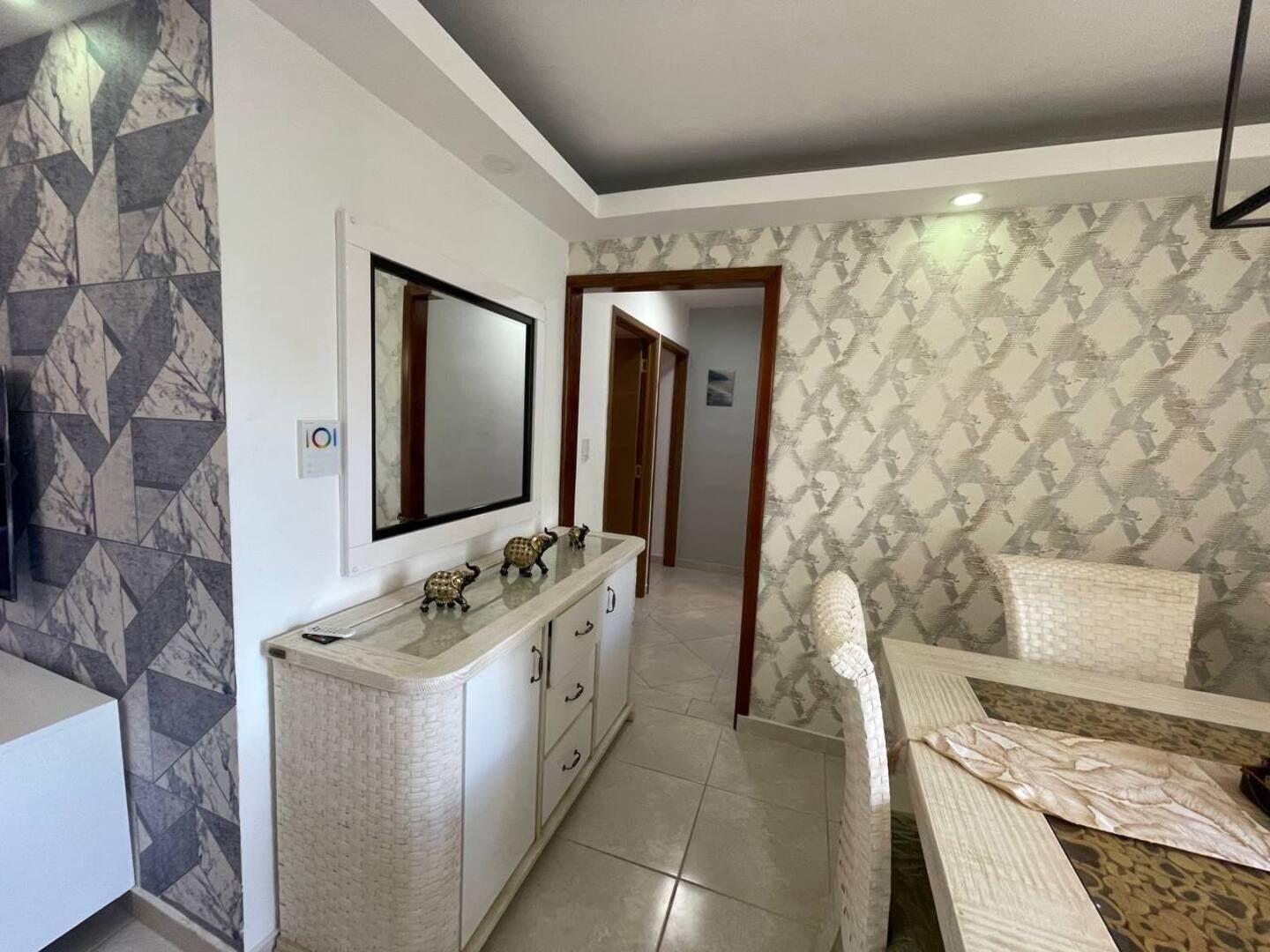 A bedroom with a bed, a vanity with a mirror, and a bathroom with a toilet.