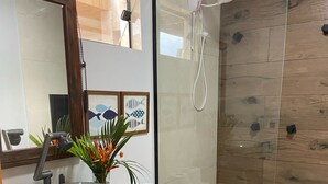 A modern bathroom with a glass shower enclosure, a vessel sink, and a toilet. - Pousada Amaris (Penha)