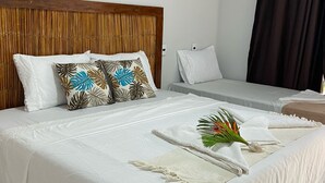 A hotel room with a large bed, a smaller bed, and a wooden headboard. - Pousada Amaris (Penha)