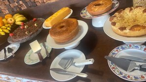 A buffet table with various desserts and fruits. - Pousada Amaris (Penha)