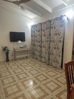 Relax in this inviting living room with a flat-screen TV, comfortable chair, and a desk for work or leisure.