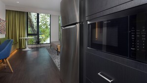 Une cuisine moderne dotée d’un réfrigérateur en acier inoxydable, d’un four encastré et d’un panneau de commande numérique.