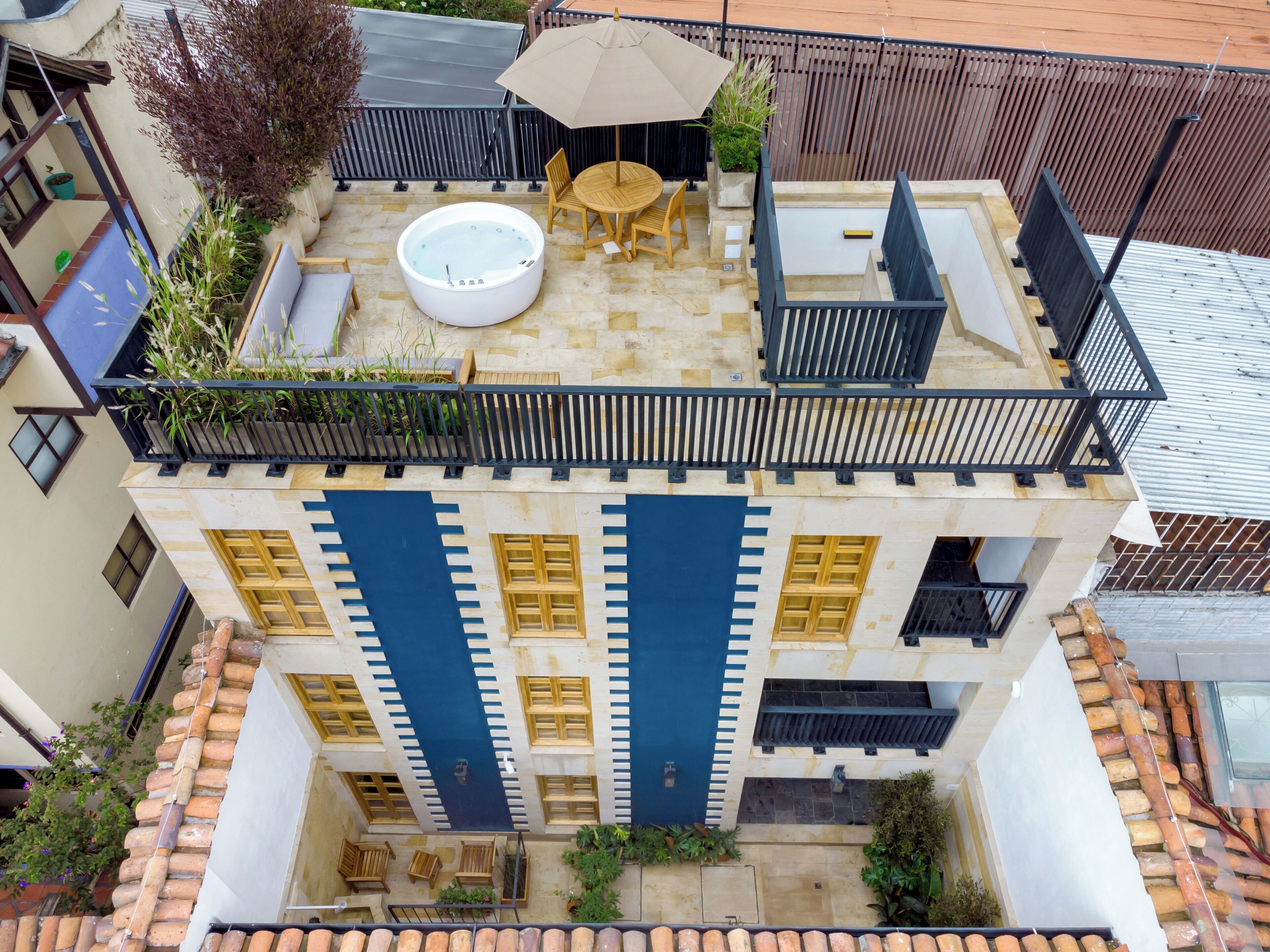 A rooftop terrace with a hot tub, outdoor seating, and a view of the city.