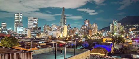 A city skyline at night with modern high-rise buildings and traditional architecture.