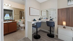 Une salle de bain moderne équipée de toilettes, d’un lavabo et de deux tabourets de bar.