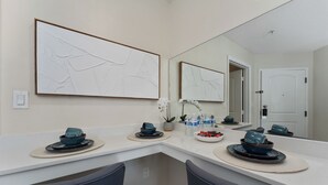 Une salle de bain moderne avec un meuble-lavabo blanc, un grand miroir et une porte.