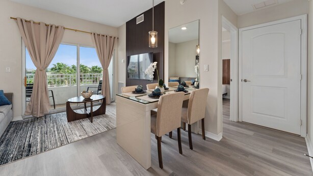A modern kitchen with a central island, a dining area with chairs, and a large window with curtains. - King Bed Suite, Kitchen, Near Theme Parks (Orlando)
