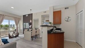 A modern apartment with a kitchen, dining area, and living room. - King Bed Suite, Kitchen, Near Theme Parks (Orlando)
