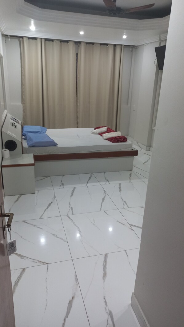 A bedroom with a bed, a bedside table, a nightstand, and a bathroom with a toilet. - Hotel mustang (Sao Paulo)