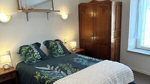 Une chambre à coucher avec un lit, une armoire, un miroir et des lampes de chevet.