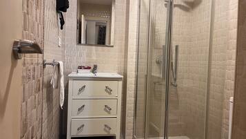 Eenpersoonskamer | Badkamer | Een douche, gratis toiletartikelen, een haardroger, handdoeken