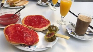 A breakfast setting with toast, jam, a glass of orange juice, a coffee cup, and a small bowl of jam. - Hostal Flor de Lis - Lojo (Conil de la Frontera)
