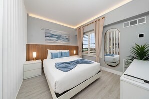 A modern bedroom with a large bed, bedside tables, a mirror, and a window with curtains. - Orlando 2BR Apt, Full Kitchen, Near Epic Universe (Orlando)