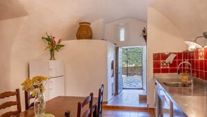 Una cocina con comedor, vista al exterior y un salpicadero de baldosas rojas.