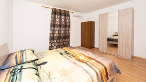 A bedroom with a bed, a wardrobe, a mirror, and a curtain. - Cozy apartment in Trogir with WiFi (Trogir)