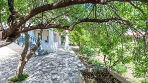 A stone-paved pathway leading to a building with a white facade and blue accents. - Cozy apartment in Trogir with WiFi (Trogir)