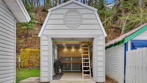 A garage with a wooden ladder, a workbench, and a garage door. - Joe's Place in Historic Wallace, Idaho (Wallace)