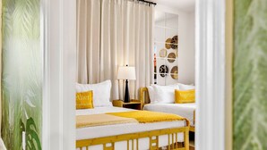 Ein Schlafzimmer mit zwei Betten, einem Nachttisch mit Lampe und einer Wand mit dekorativen Tellern.