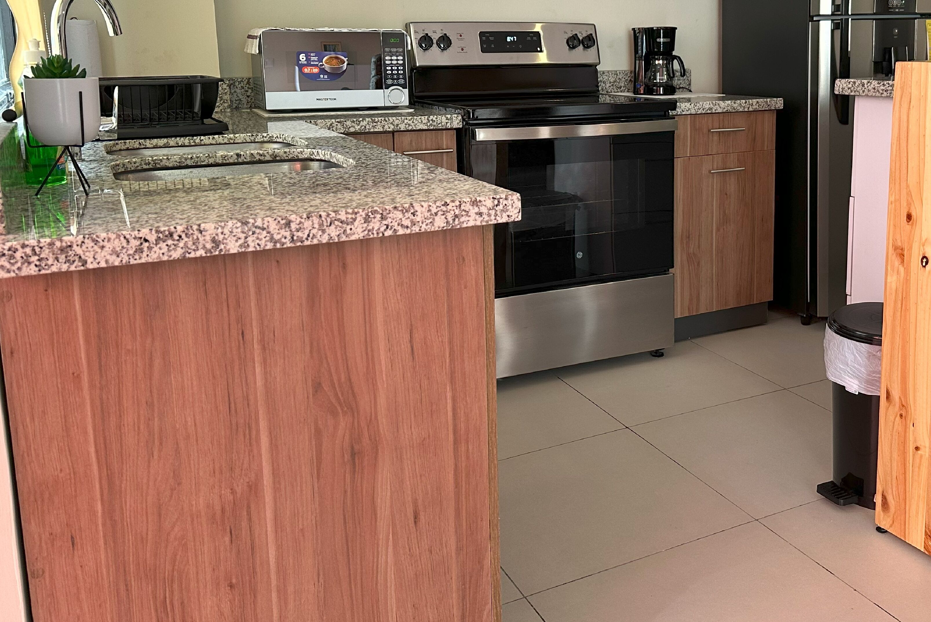 A kitchen with granite countertops, stainless steel appliances, and wooden cabinets.