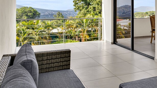 A balcony with a view of a cityscape and mountains.
