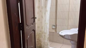 Een douche, handdoeken, zeep, toiletpapier