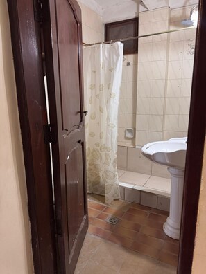 Een douche, handdoeken, zeep, toiletpapier