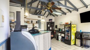 A restaurant interior with a counter, ceiling fan, and various kitchen appliances. - Colony Inn By OYO Columbus US-280 (Columbus)