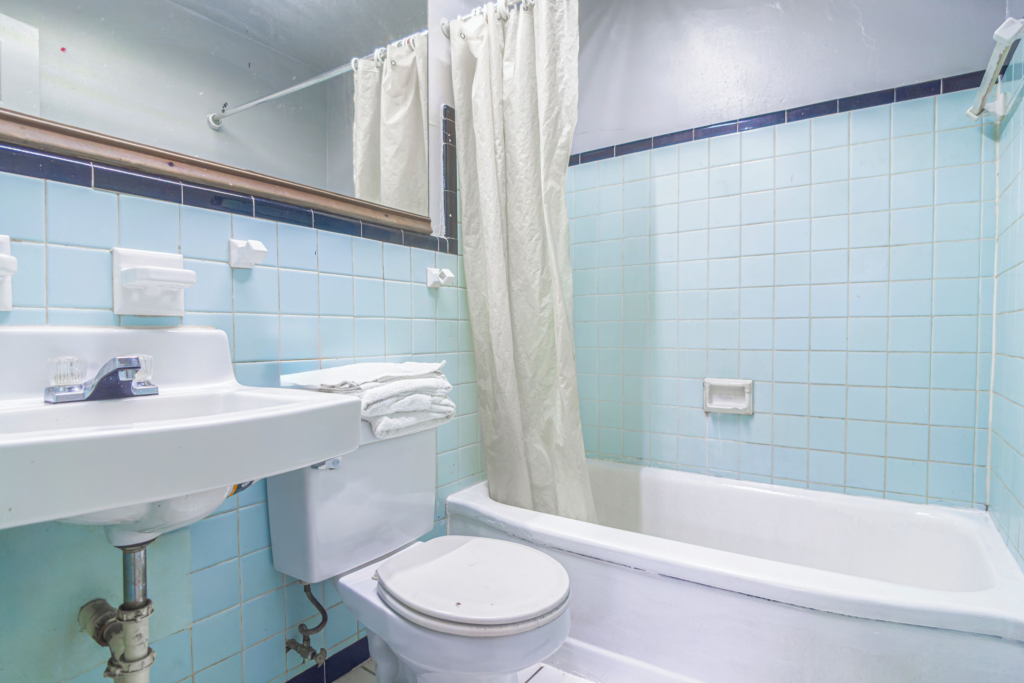 Een badkamer met een witte wastafel, toilet en bad.