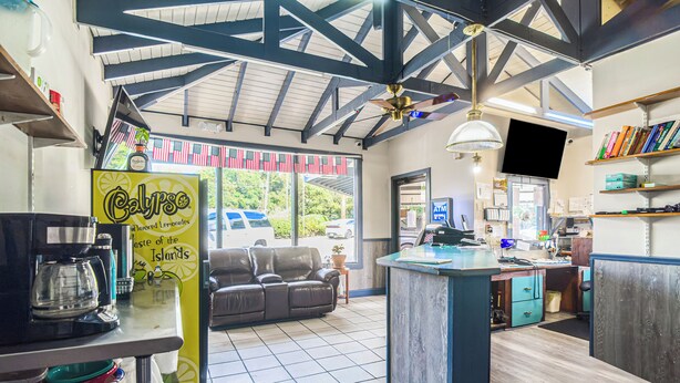 A restaurant with a counter, a sofa, and a TV. - Colony Inn By OYO Columbus US-280 (Columbus)