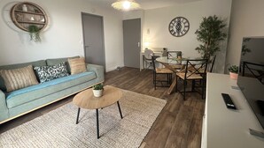A living room with a sofa, coffee table, and dining area with chairs and a table. - 1 bedroom private vacation home in albi (Albi)