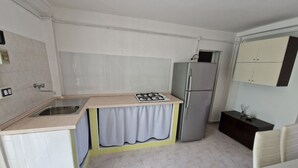 Eine Küche mit Spüle, Herd, Kühlschrank und einem Essbereich mit Tisch und Stühlen.