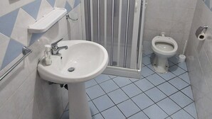 Ein Badezimmer mit Waschbecken, Toilette und Dusche.