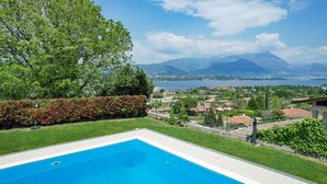 A swimming pool with a view of mountains and a lake.