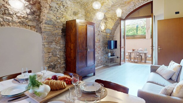 A dining area with a stone wall, wooden cabinet, and a table set for a meal.