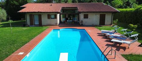 Relax by the pool surrounded by lush greenery and enjoy the view from the balcony.