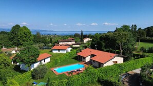 A residential area with houses, a swimming pool, and a view of the sea.