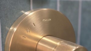 Une poignée de porte en laiton portant la marque « Kohler » gravée dessus.
