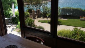 Ein Zimmer mit Blick auf einen Garten und ein Gewässer.